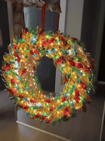 Colorful Christmas bulb wreath shown close up and hanging on a door