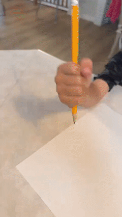 Ergonomic writing aid pencil demonstrating grip activated writing mechanism