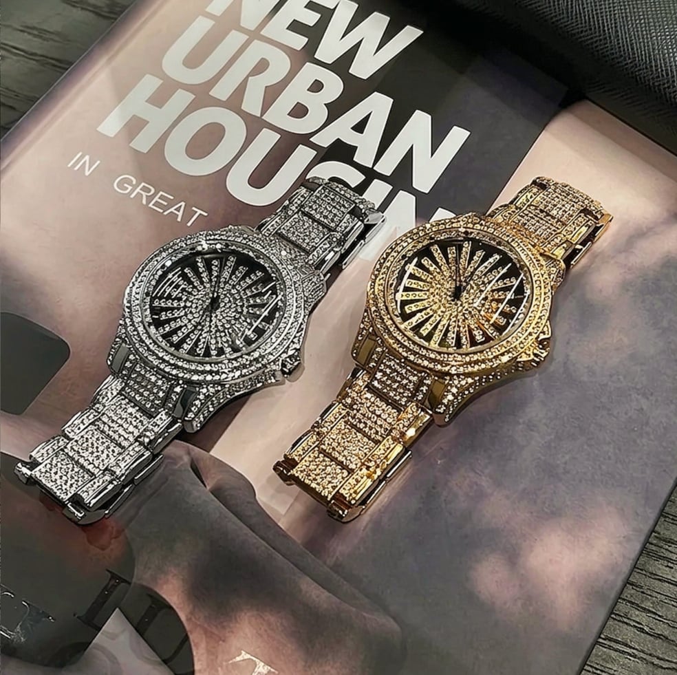 Handheld gold iced out watch showing wrist scale and sparkle