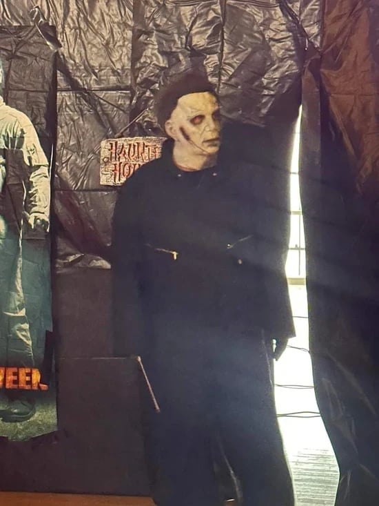 Costume fan wearing a character mask at a Halloween attraction