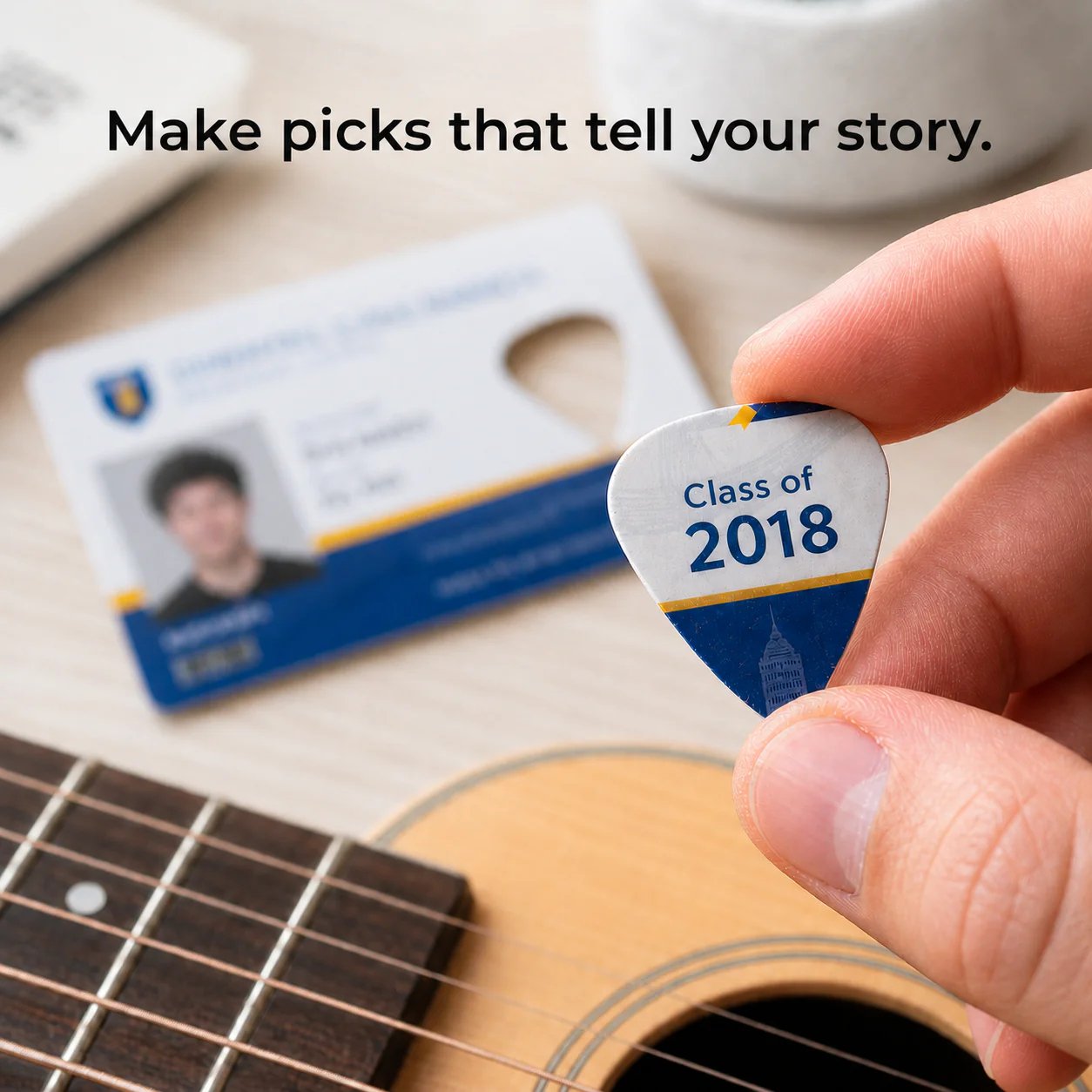 Custom guitar pick held beside an acoustic guitar