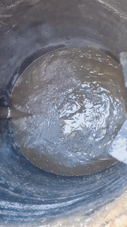 High-pressure sewer jet nozzle clearing a drain