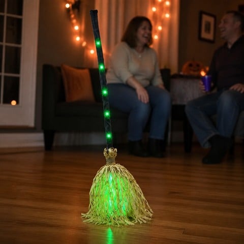 Friends laughing as the animated broom moves in a living room