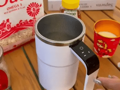 White rechargeable self-stirring mug mixing a creamy coffee