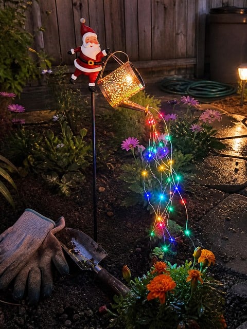 Multicolor Santa garden light in a backyard flower bed
